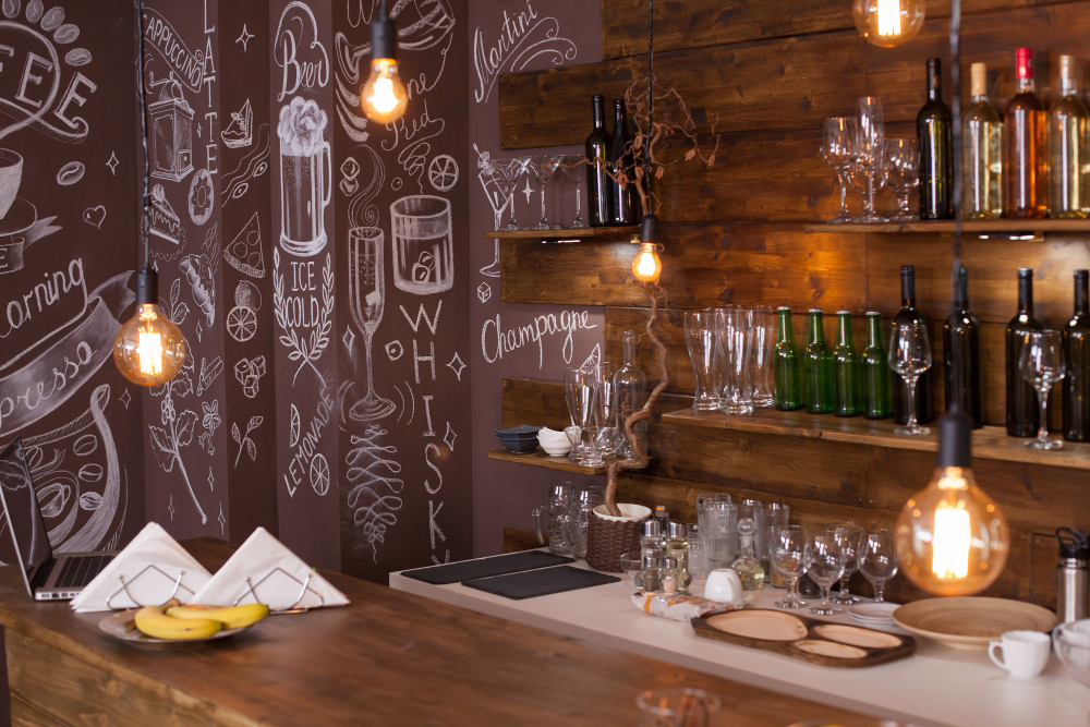 A unique bar decor idea featuring a floor-to-ceiling chalk mural behind a rustic wooden bar with warm, inviting lighting.