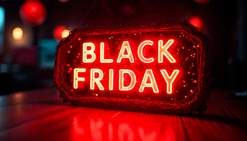 Close-up of a neon "BLACK FRIDAY" sign against a blurred background of a bar interior.