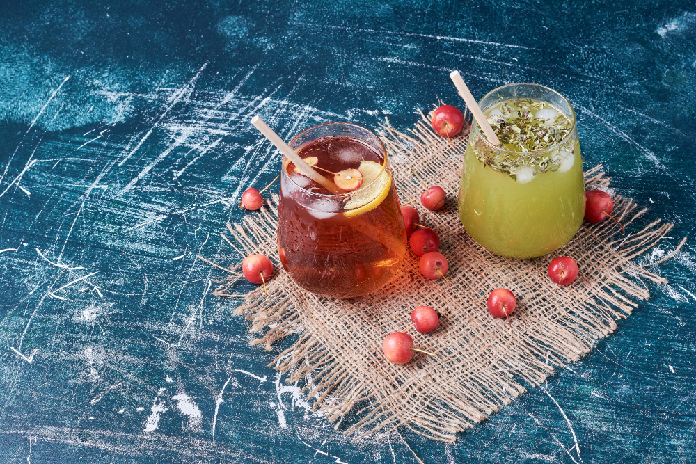 High-margin non-alcoholic drinks for Dry January featuring a zero-proof dark spirit and a vibrant green botanical infusion.